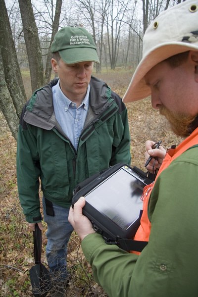 Dr, Duane Diefenbach, instructs student on use hand-held computer units; Photo by Gordon Harkins