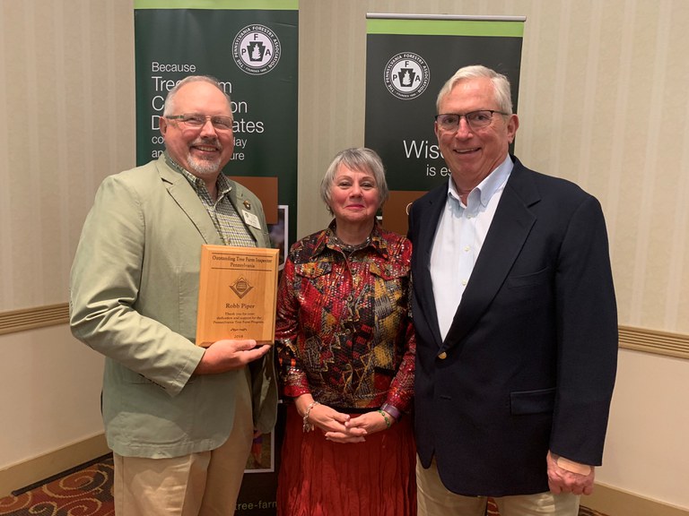 Robb Piper (left) receives the 2018 Outstanding Inspector of the Year Award from John and Maureen Burnham (Photo by Caleb Wright)