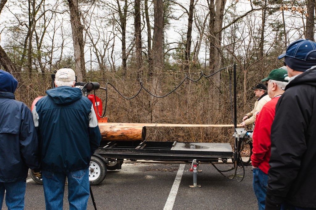 Scott Weikert, Resources Educator, Penn State Extension, shows the group a freshly trimmed board from the sawmill.  Photo credit: Laura Kirt Studios