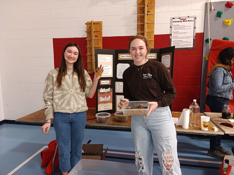 (Left to right) MaryBeth Gavin and Megan Kownurko demonstrate soil hand texturing at an elementary school Science and Technology Fair. MaryBeth and Megan were ERM students (Class of 2023) and members of the Penn State Soil Judging team.