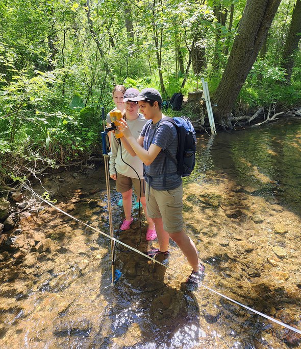 Pictured left to right are summer interns Maria Giarrusso, Amanda Rill and Jes Hosch learning to use a FlowTracker to measure stream flow in the Shale Hills watershed.